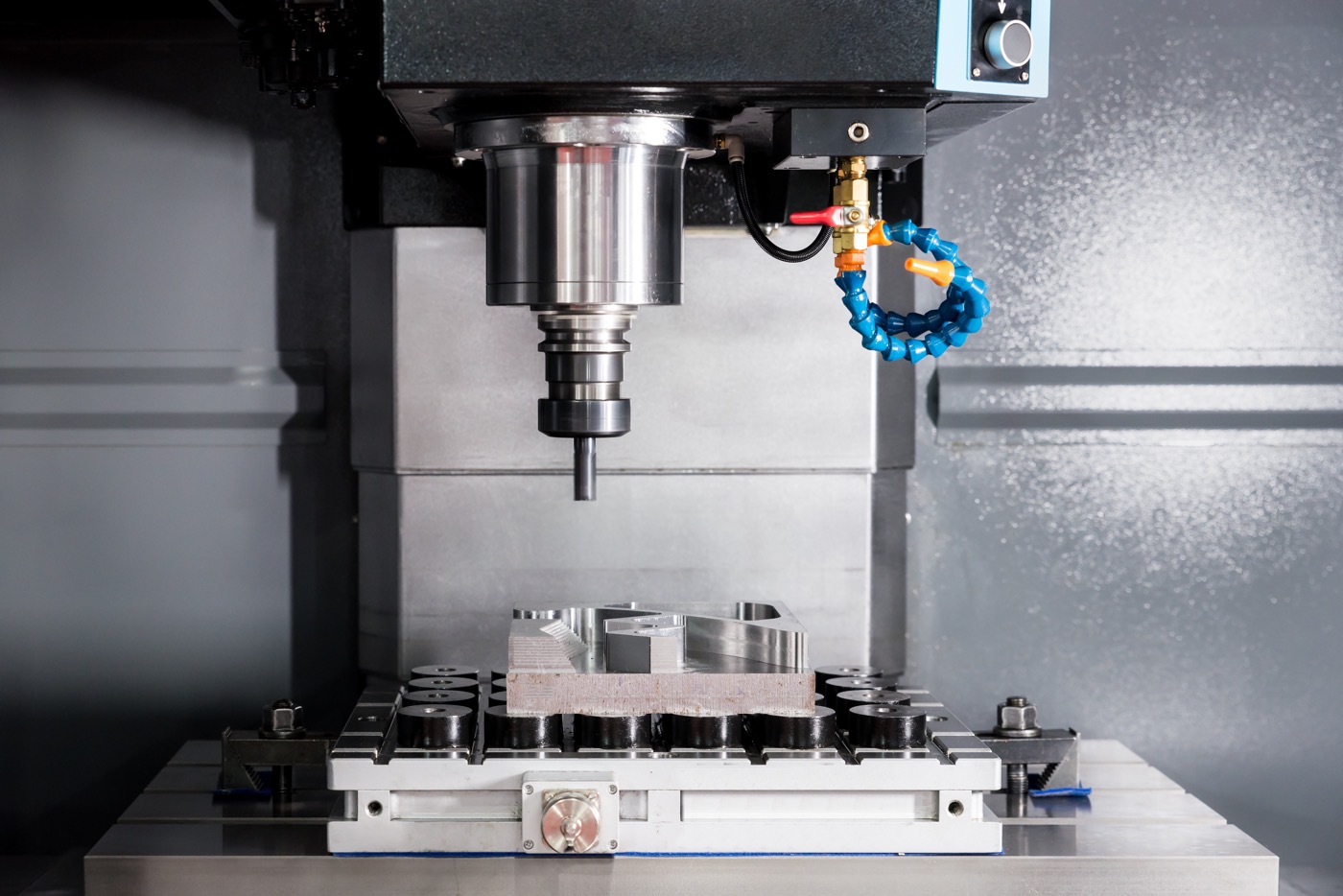 EDM or CNC industry machine working with coolant injection in industry factory. Low light.